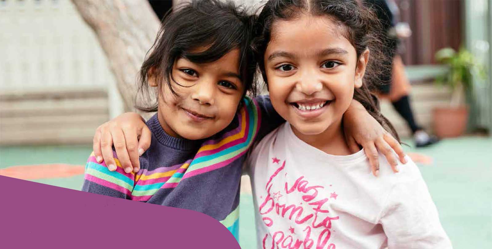 Two young girls smiling to camera