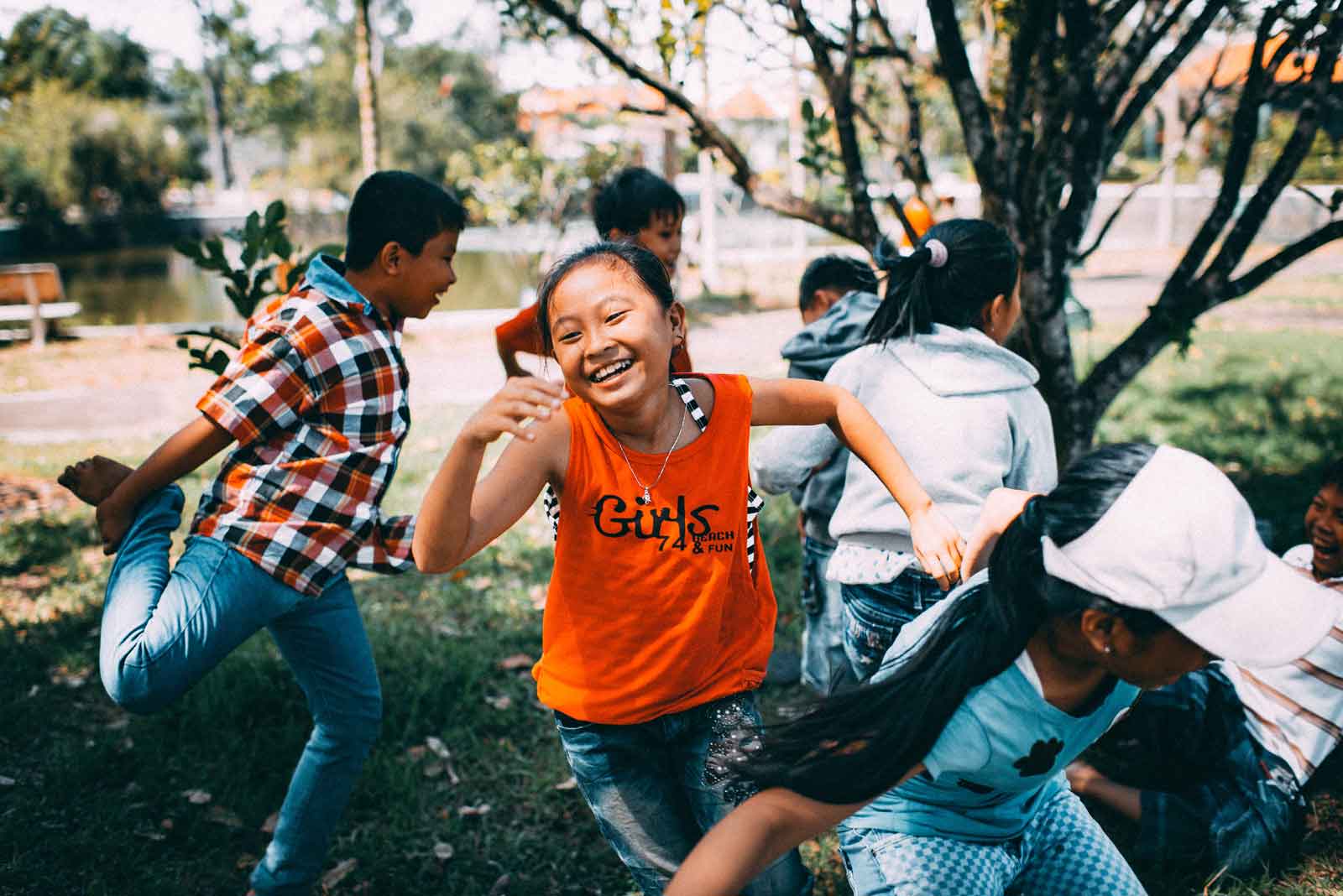 Young children dancing and playing in park