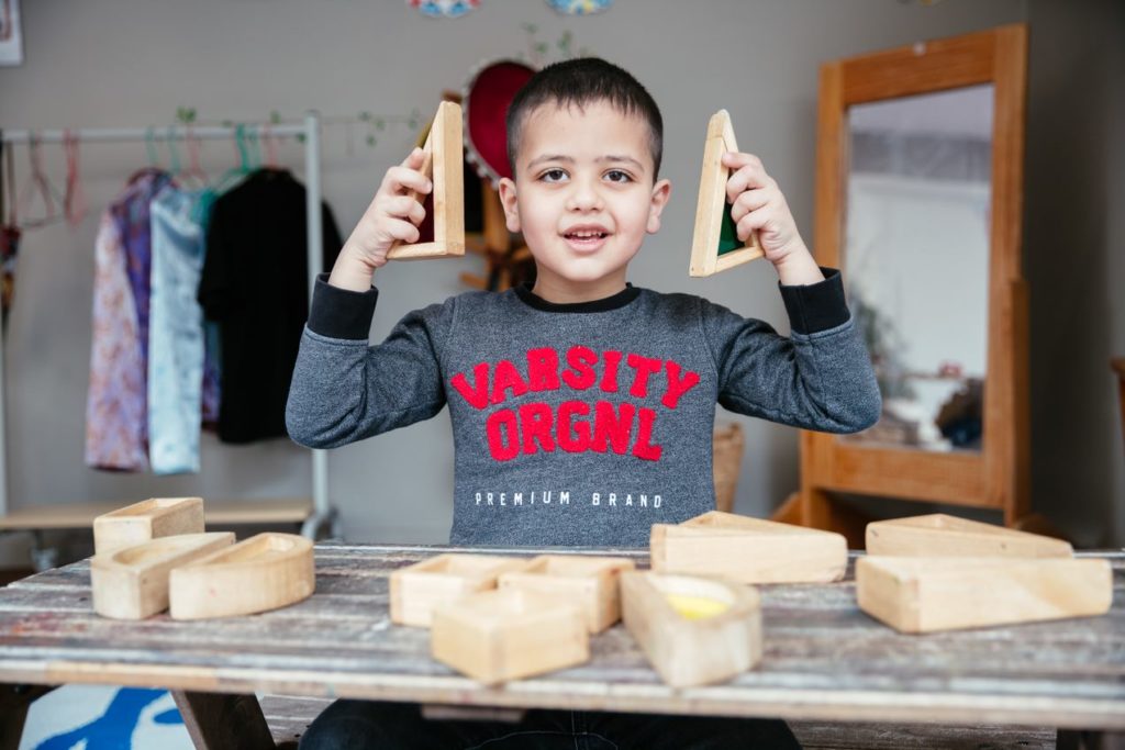 Young boy holding wooden play blocks