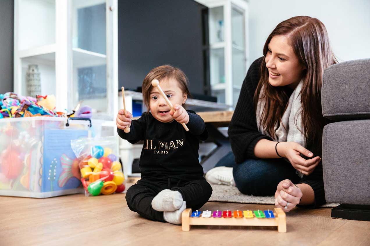 Mother with child playing with musical toy