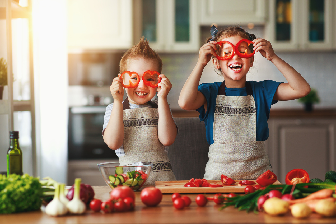 Healthy eating. Happy children prepares and eats vegetable salad in kitchen